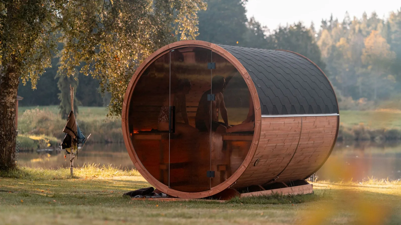 Sauna beczka w ogrodzie nad wodą