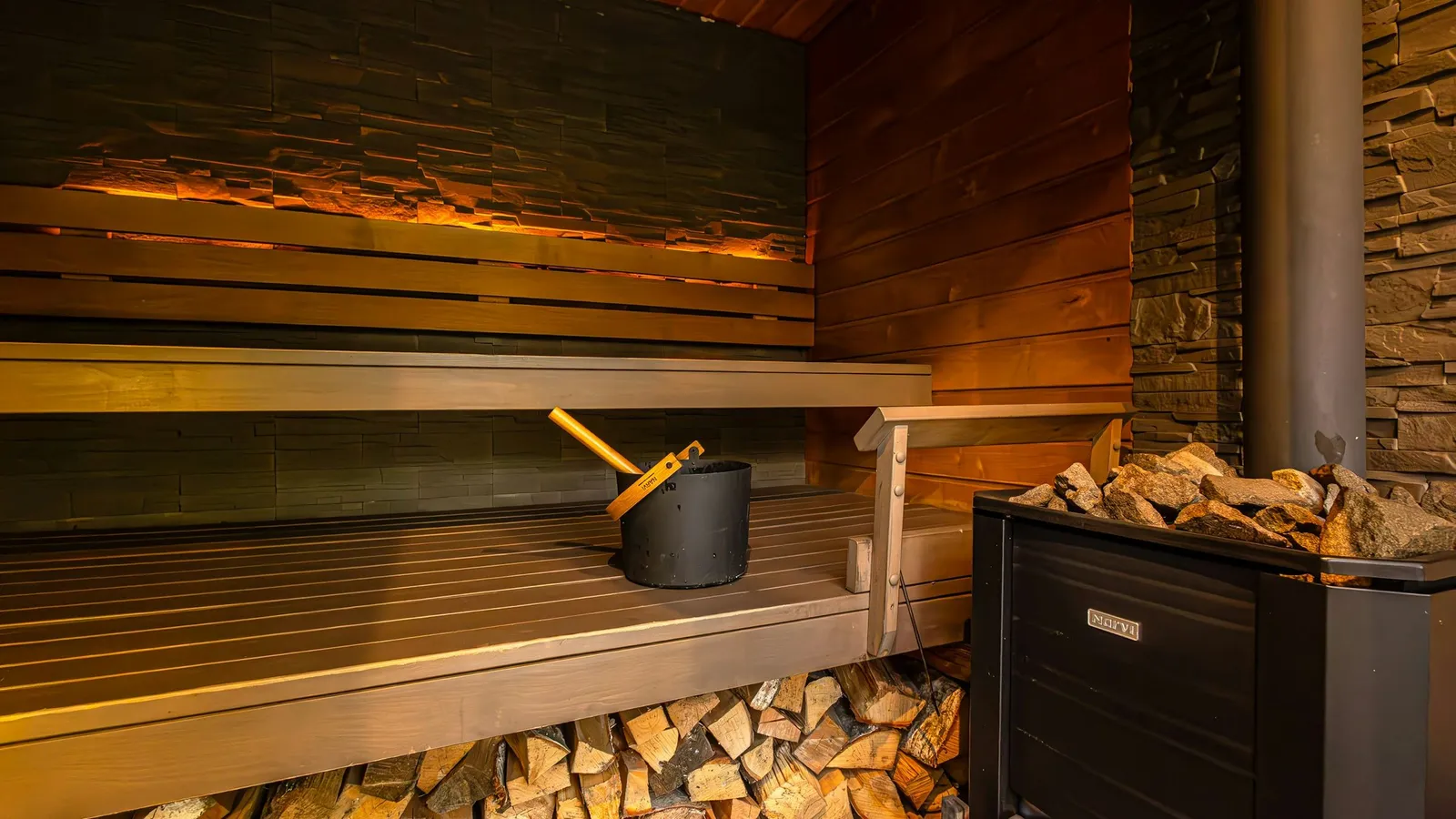 Sauna z drewnianymi ławami i piecem opalanym drewnem