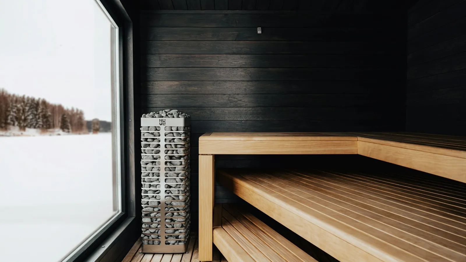 Czarna sauna z oknem na śnieg
